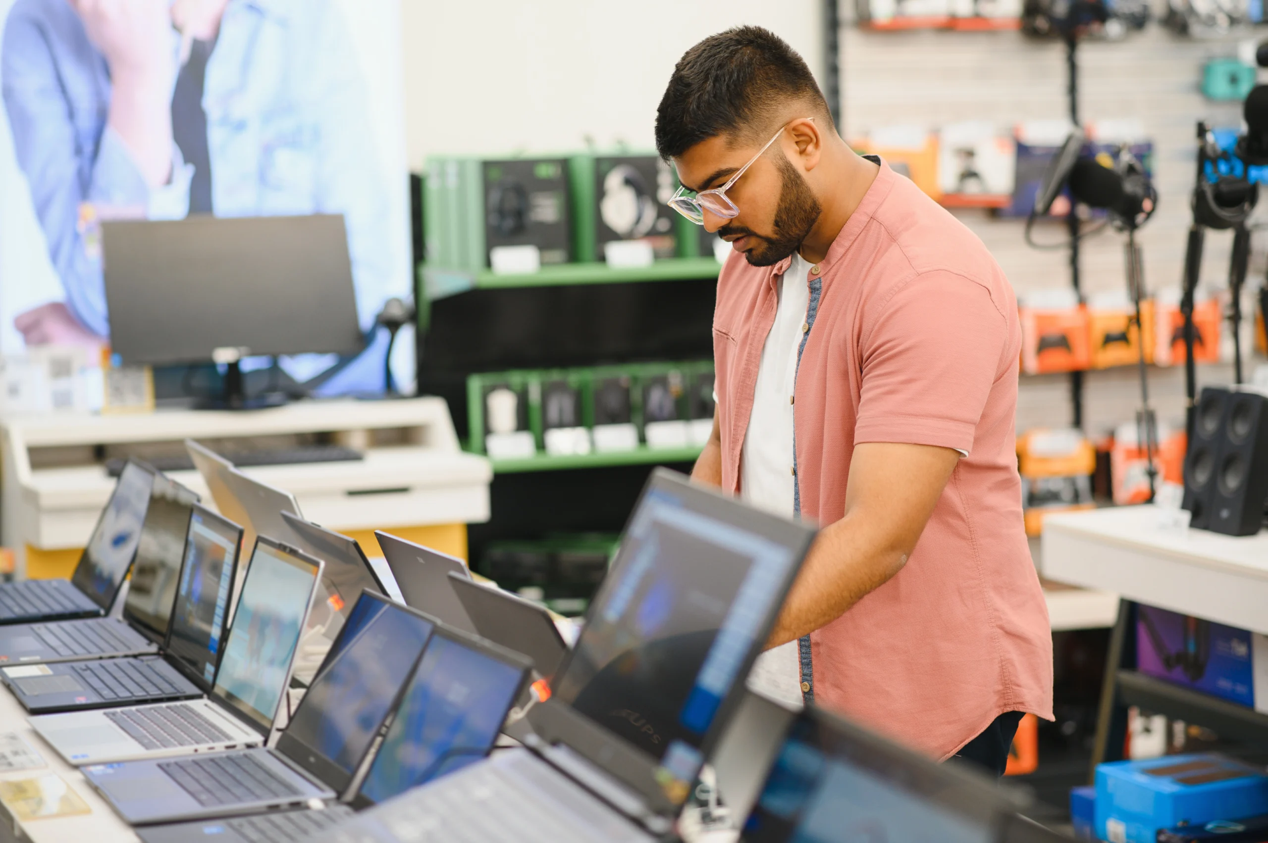 a-young-man-stands-behind-his-laptop-at-the-electr-2025-03-14-22-56-08-utc