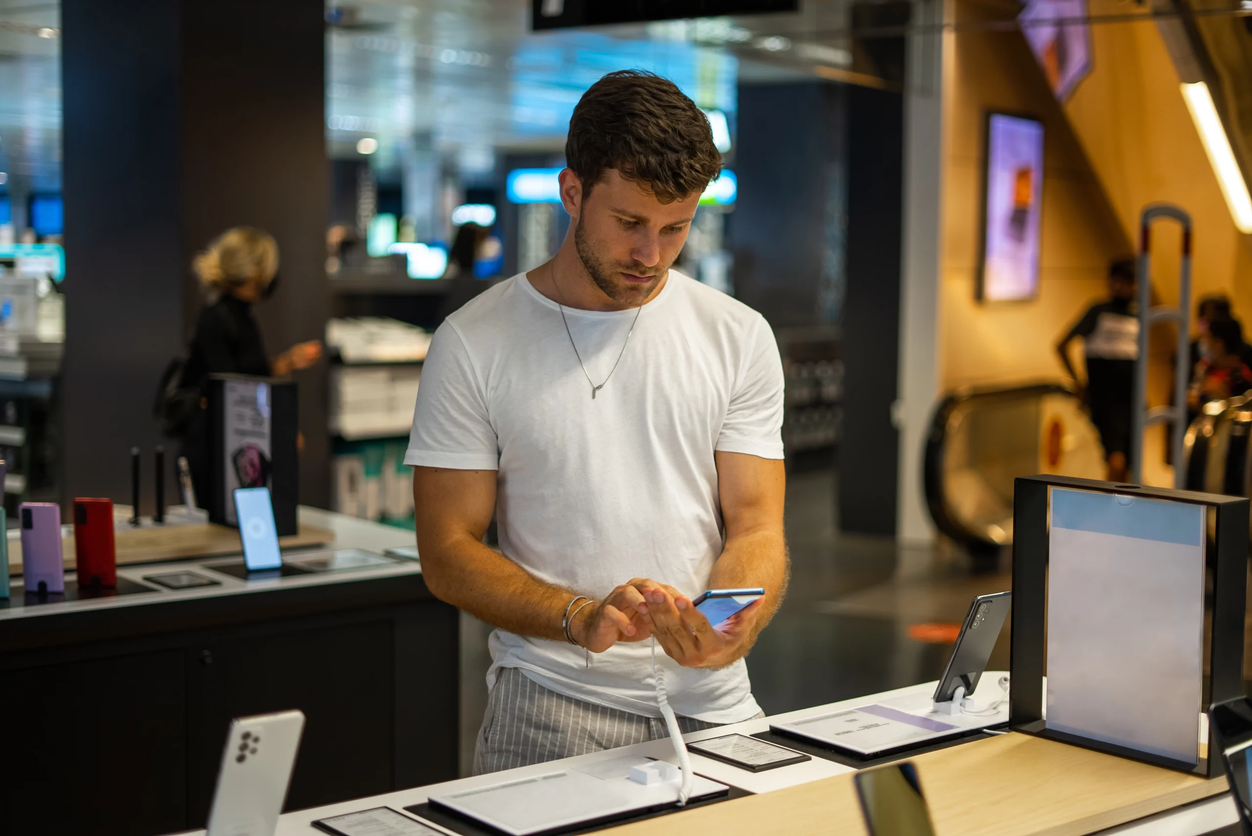 focused-man-choosing-smartphone-in-electronics-sto-2025-02-12-18-41-41-utc